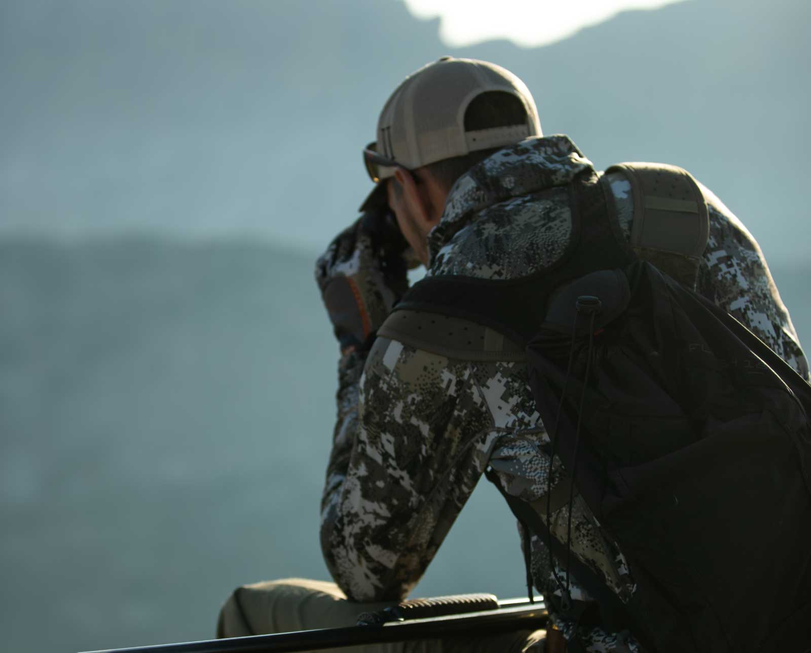 A hunter uses optics to spot Himalayan snowcock.