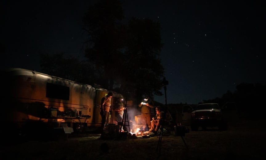 Bird hunters eat quail around a campfire in Arizona.