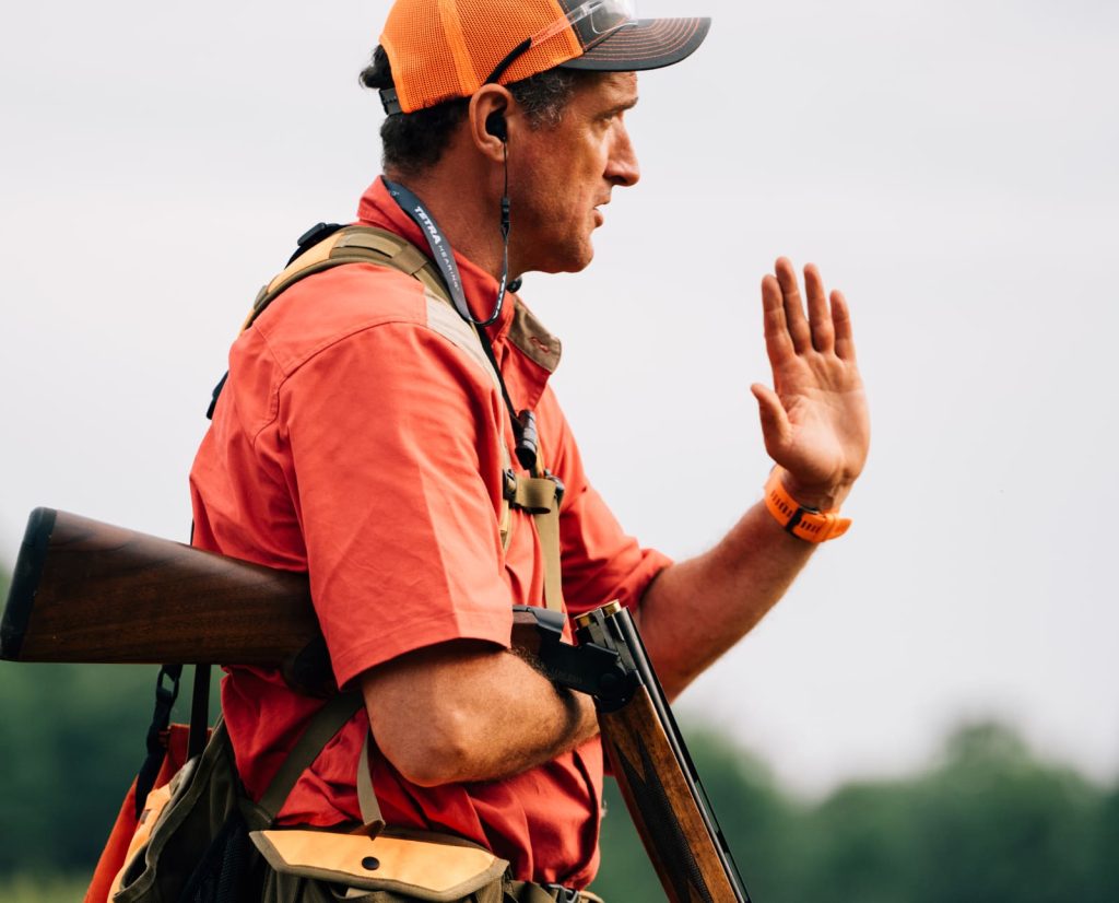 A dog training gives a visual steady command during training of a pointing dog.