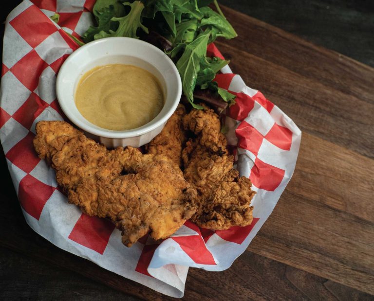Fried crispy pheasant tenders in a basket with dipping sauce.