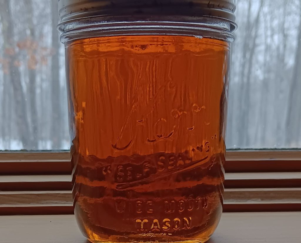 A mason jar of homemade maple syrup.