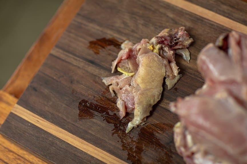 Trimmed, freezer-burned pheasant meat on a wood cutting board