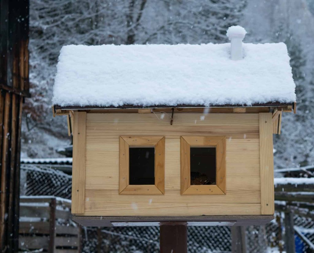A wintersized quail hutch in the snow.