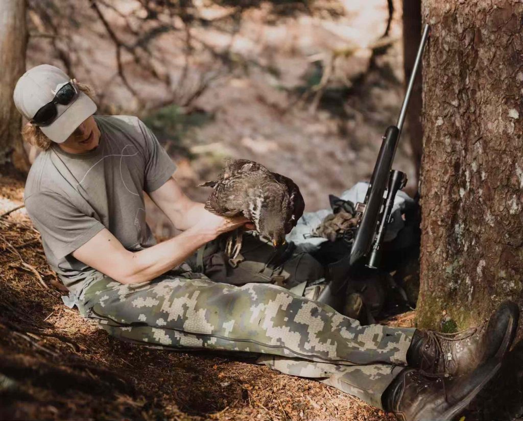 A bird hunter holds a male sooty grouse in Alaska