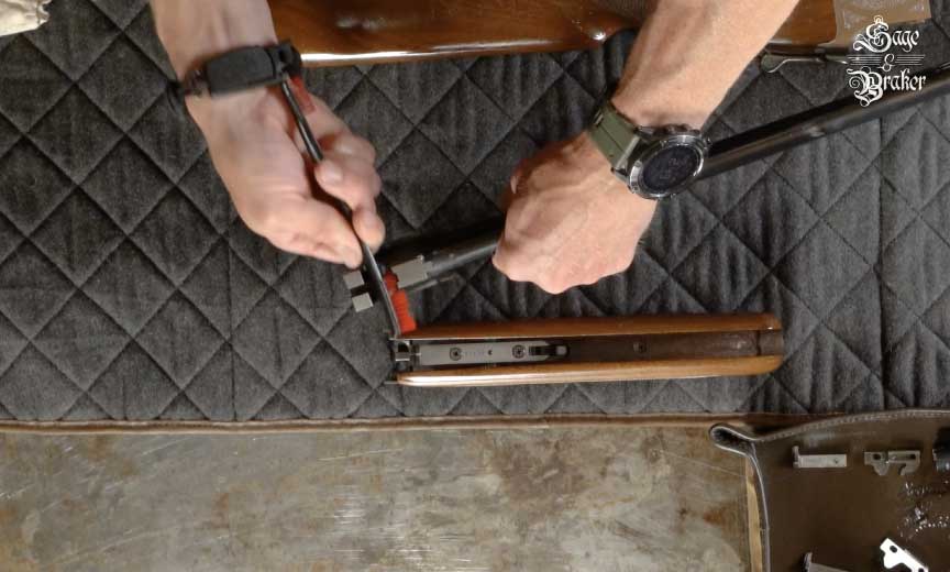 brushing metal parts of shotgun with nylon brush