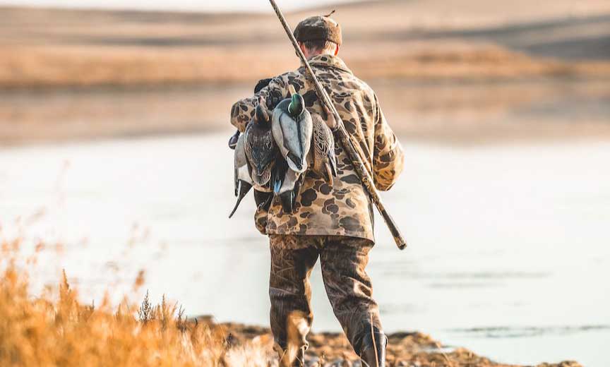 a duck hunter sets up a small spread of decoys.