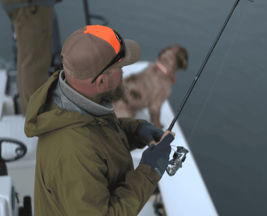 A bird hunter casts a fishing rod with his bird dog.