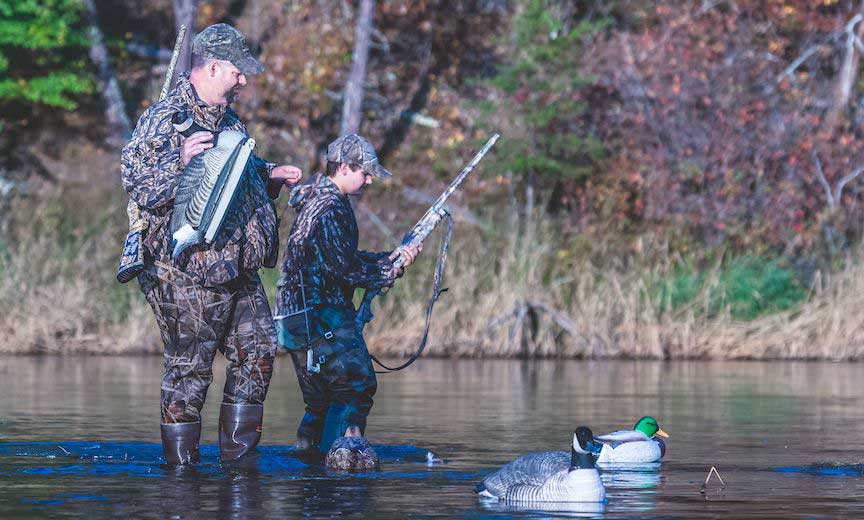 a hunter mentors a young duck hunter.