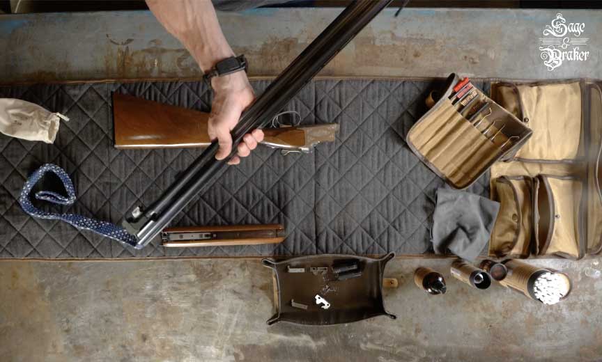 hunter runs a bore brush through barrels of shotgun 